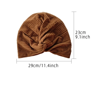 Brown elastic turban hat with striped texture and front twist knot design details