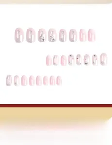 Detail of pink gradient press-on nails with silver stars and pearl accents on oval tips