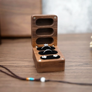Detailed view of black walnut wood ring box with three slots and black velvet lining
