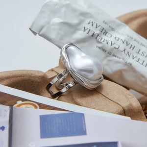 Close-up of baroque faux pearl ring on silver titanium steel with polished finish