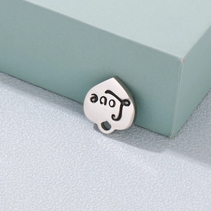 Pendentif cœur en acier inoxydable poli avec gravure love noire sur support vert