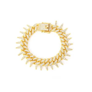 Gold iced-out Cuban chain necklace with thorns and white rhinestones on white background