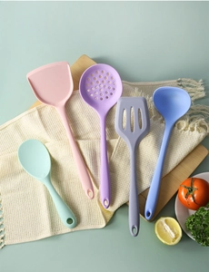 Top-down view of a 5-piece colorful silicone kitchen utensil set on a wooden board