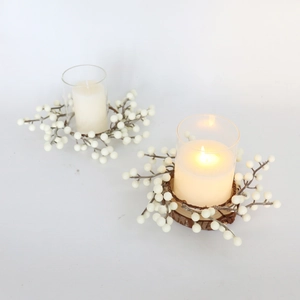 Détail d'un bougeoir couronne de baies blanches avec base en bois et verre