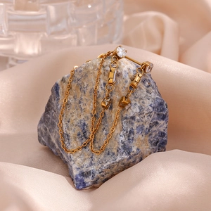 Detailed close-up of golden tassel chain earrings with sparkling cubic zirconia crystals