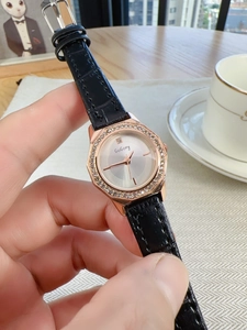 Close-up of luxury women's watch with rose gold diamond octagonal bezel and black leather strap