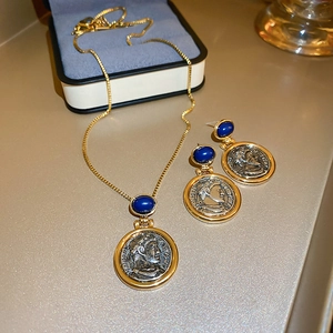 Detailed close-up of vintage coin jewelry set with blue gemstones and portrait relief