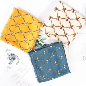 Silk square scarf featuring horse prints in yellow, cream, and blue colors