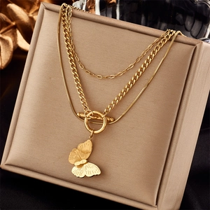 Detail of bohemian gold triple layer necklace with butterfly pendant and OT buckle toggle