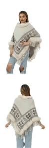 Detail of winter knitted poncho featuring faux fur collar and snowflake pattern with tassels