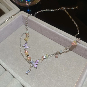Detailed shot of purple butterfly charms and colorful gravel on a silver chain necklace
