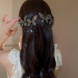 Detail of elegant butterfly hair clips with shimmering rhinestones and beaded tassels