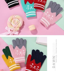 Flat lay of colorful knitted kids cat gloves with striped cuffs and cute patterns