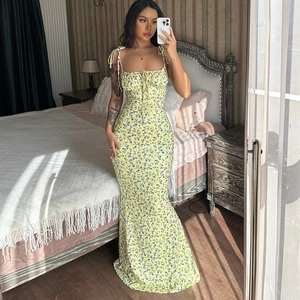 Detail of floral summer maxi dress with blue small flower print on a yellow background