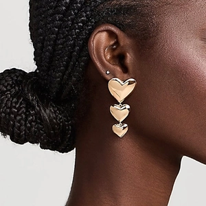 Boucles d'oreilles pendantes triple cœur dorées pour un look élégant et audacieux
