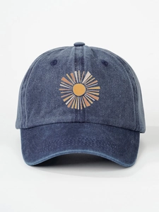 Detail of vintage washed navy baseball cap featuring an embroidered orange sunburst pattern