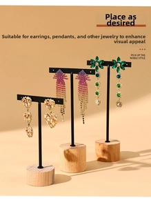 Close-up of three T-bar earring displays with cylindrical wooden bases and black metal frames