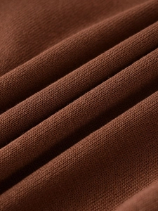 Close-up of chocolate brown knit fabric showing soft texture and fine stitching detail