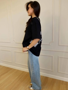 Side view of a casual black oversized t-shirt paired with light blue wide-leg denim jeans