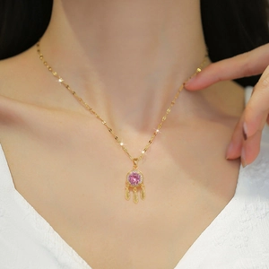 Gold dreamcatcher necklace with pink stone and feathers on model for elegant style