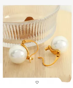Gros plan de boucles d'oreilles perles élégantes avec crochets dorés sur bois