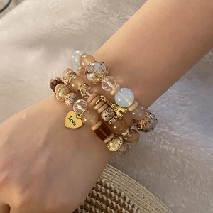 Dettaglio di braccialetti con perline e ciondoli a cuore Love e Torre Eiffel