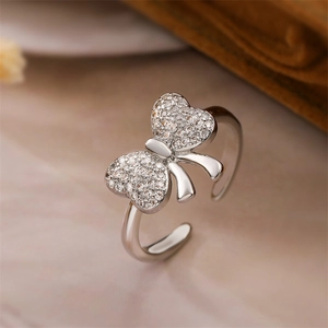 Primo piano di un anello a fiocco argento con micro-pavé di zirconi e finitura lucida