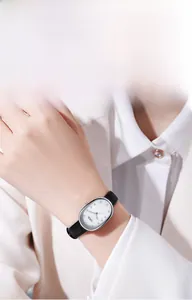 Close-up of elegant oval quartz watch with mother-of-pearl dial and black leather strap