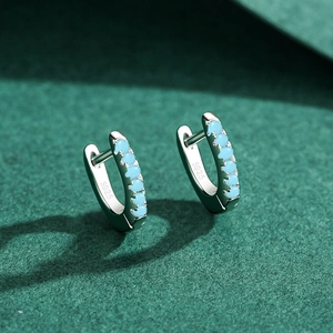 S925 sterling silver hoop earrings with turquoise beads on green textured background