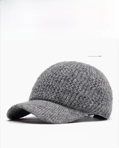 Detail shot of a grey cable knit baseball cap showing the thick textured woven fabric