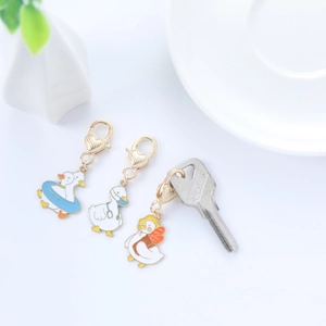Close-up of three cute enamel duck charms with blue swim ring and heart lobster clasps