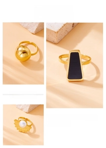 Detail of three gold rings featuring minimalist dome, black enamel, and pearl accents