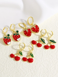 Detailed view of four pairs of strawberry and cherry enamel earrings with gold accents