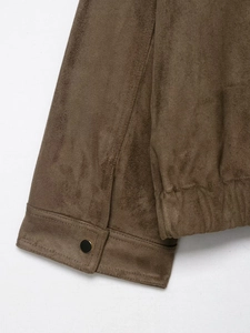 Detailed macro view of brown faux suede jacket sleeve cuff with button and elastic hem