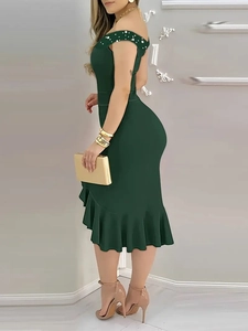 Detail of dark green off-shoulder dress with white pearl accents and ruffled hem design