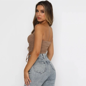 Détail d'un haut court marron dos nu avec cordon de serrage et jean denim