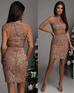 Detail of sequin halter dress featuring layered bead tassels and champagne finish