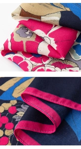 Macro detail of geometric floral print scarf showing twill texture and neat rose pink edging