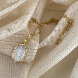Macro detail of 925 sterling silver Virgin Mary medallion with white shell inlay