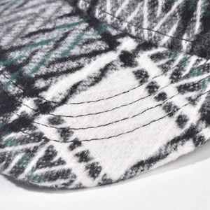 Close-up of thick plaid wool fabric and detailed reinforced stitching on the baseball cap