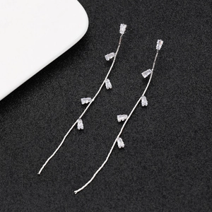 Detailed macro view of silver long tassel earrings with rectangular cubic zirconia accents