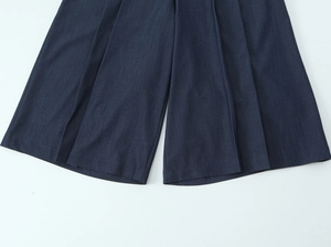 Gros plan du short large bleu foncé avec coutures précises et texture de tissu denim
