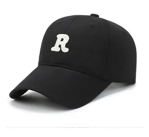 Detail of black baseball cap with white towel-embroidered R letter and twill cotton texture