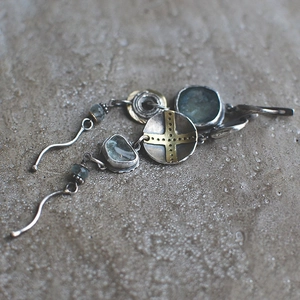 Detail of tribal asymmetric earrings with sky blue stones and vintage metal cross