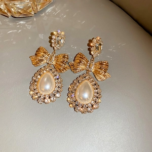 Détails de boucles d'oreilles nœuds dorés avec perles gouttes et cristaux brillants