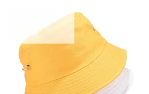 Détail d'un bob jaune en coton avec anneaux métalliques décoratifs et large bord