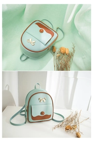 Detail view of mini mint green and brown leather backpack with gold bow hardware