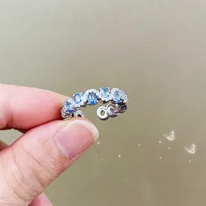 Macro detail of silver adjustable ring with light blue oval gemstones and white diamonds