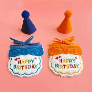 Detailed view of blue and orange embroidered happy birthday pet bibs and party hats