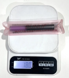 Gros plan montrant le poids de 18,0g du rouge à lèvres mat violet foncé sous emballage scellé